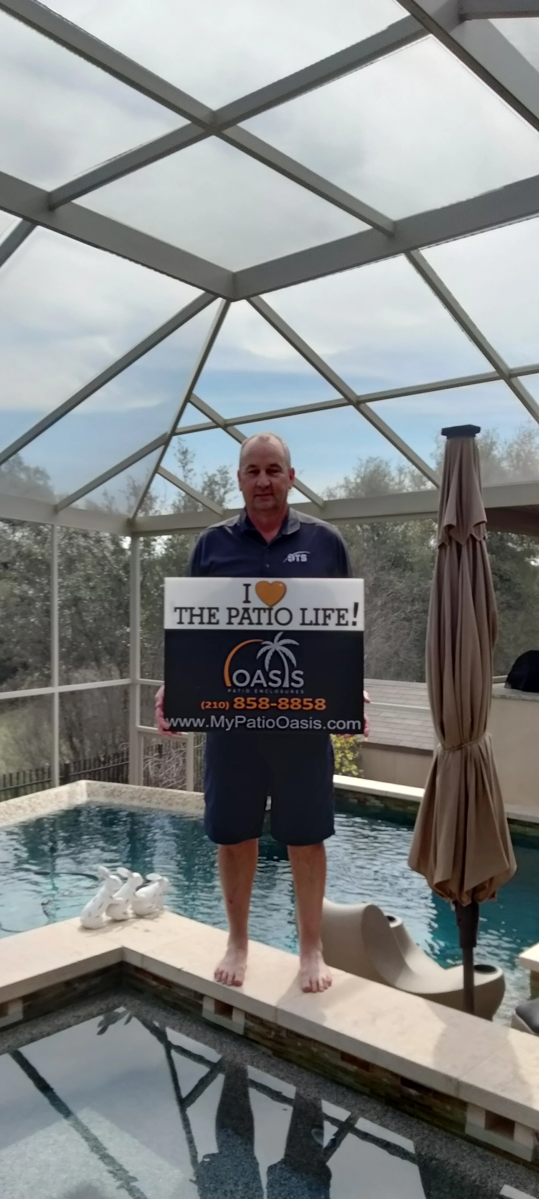 Aluminum patio enclosure with polycarbonate roof panels over swimming pool