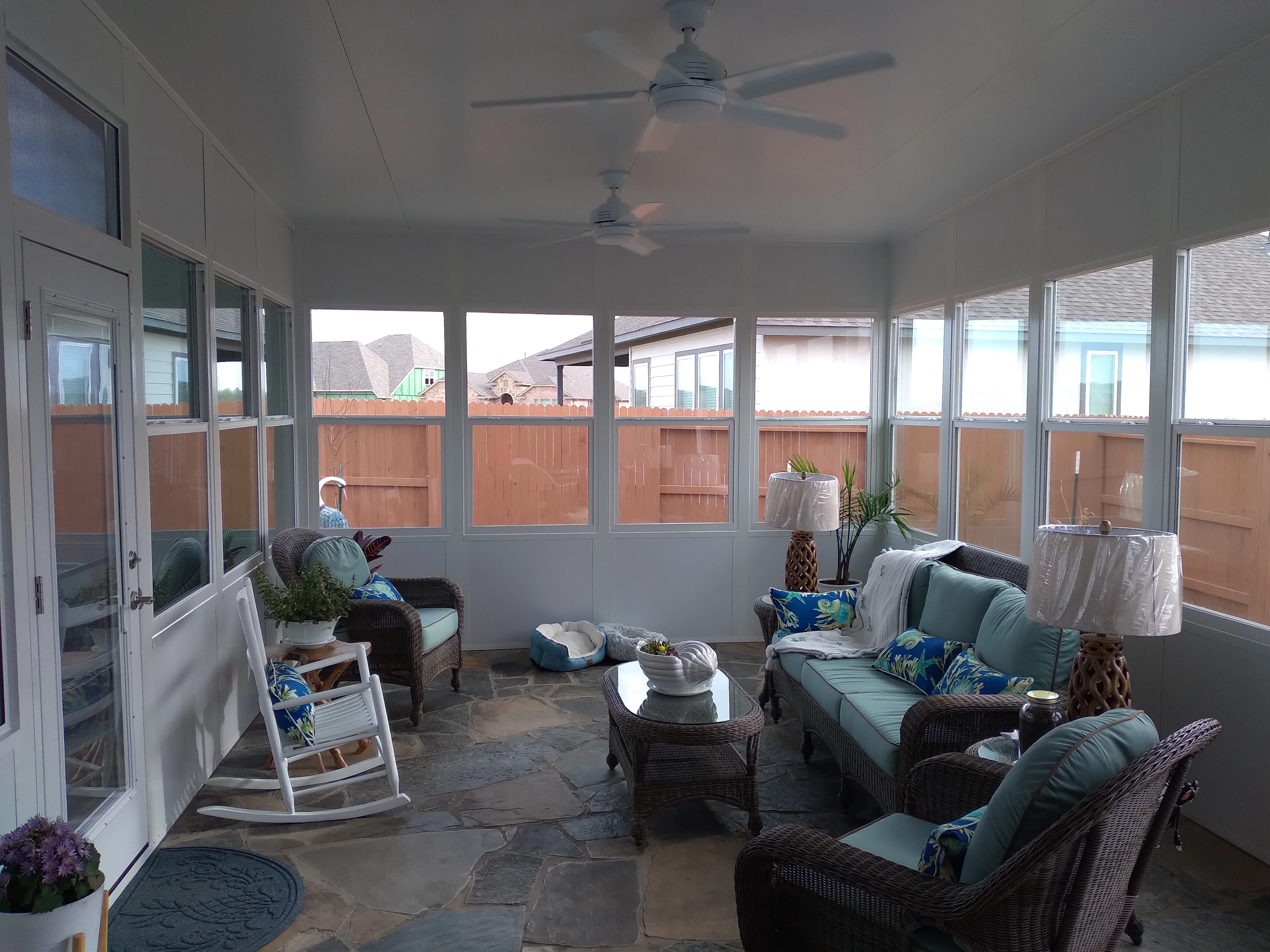 Enclosed patio with aluminum glass panels, drywall ceiling, ceiling fans, and slate flooring