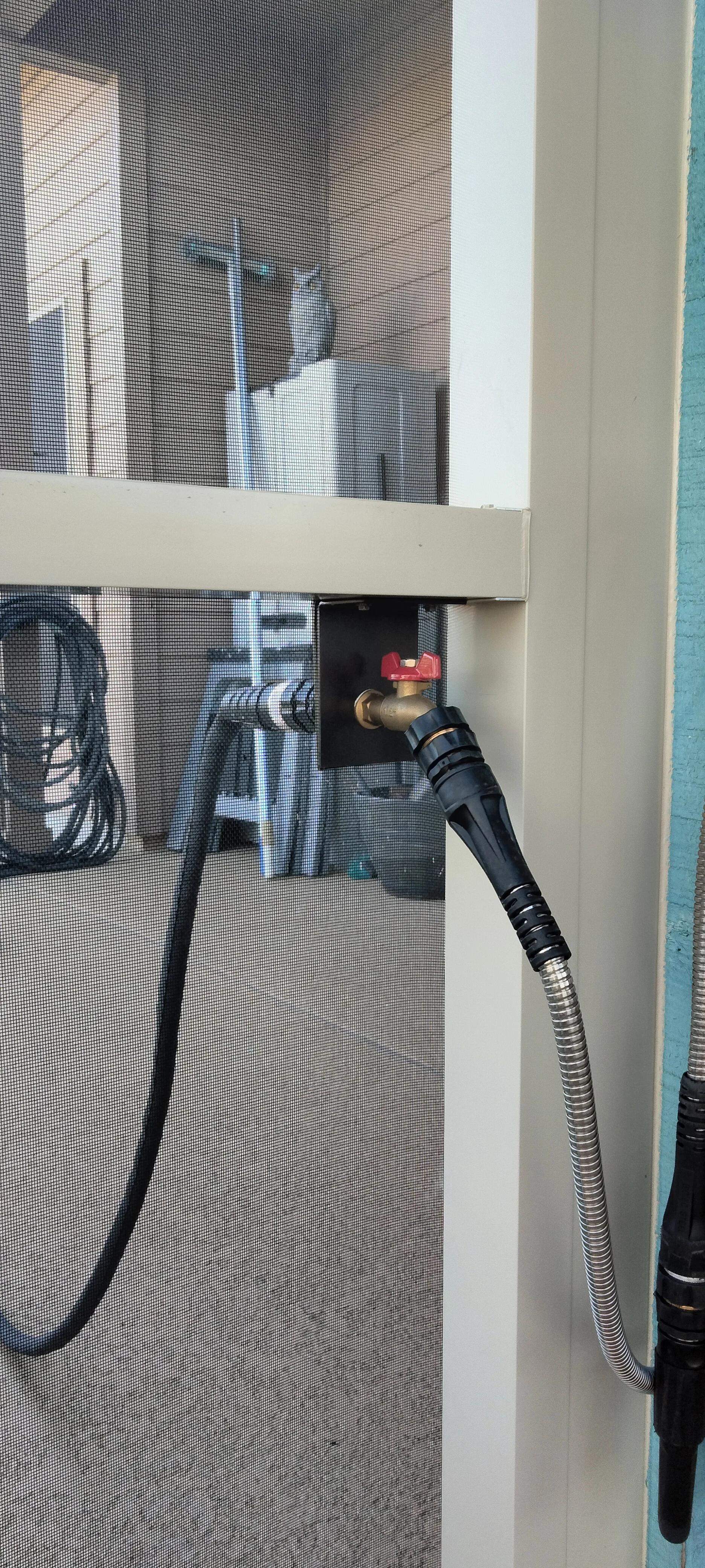 Patio enclosure with brass ball valve, flexible hose connections, and mesh screening installation