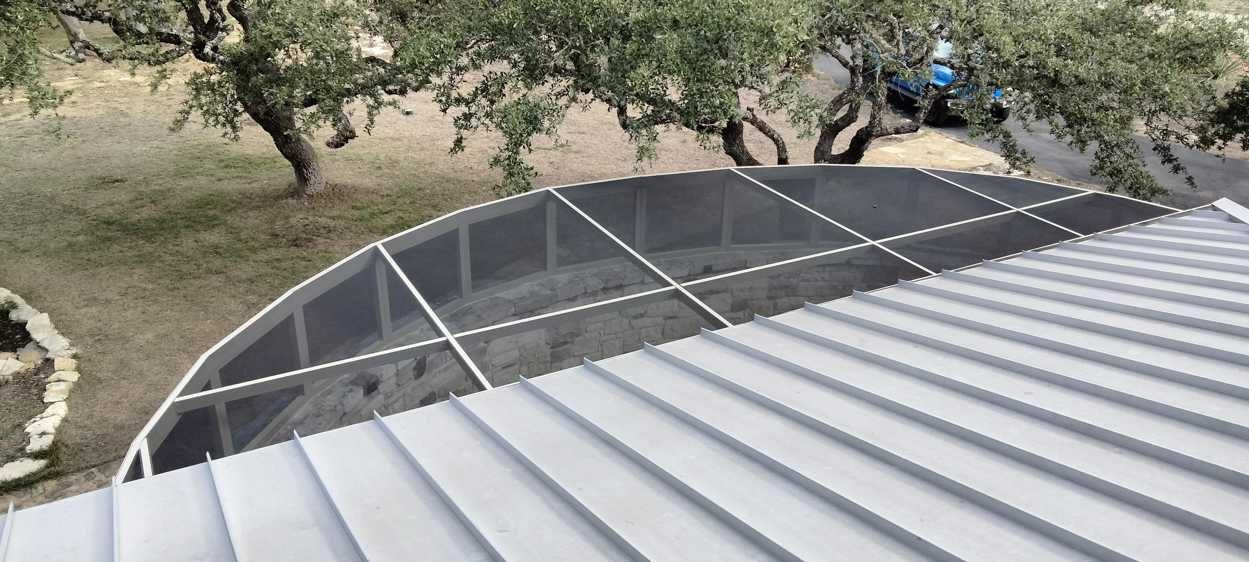 Curved aluminum patio frame with polycarbonate roof panels and white trim under construction