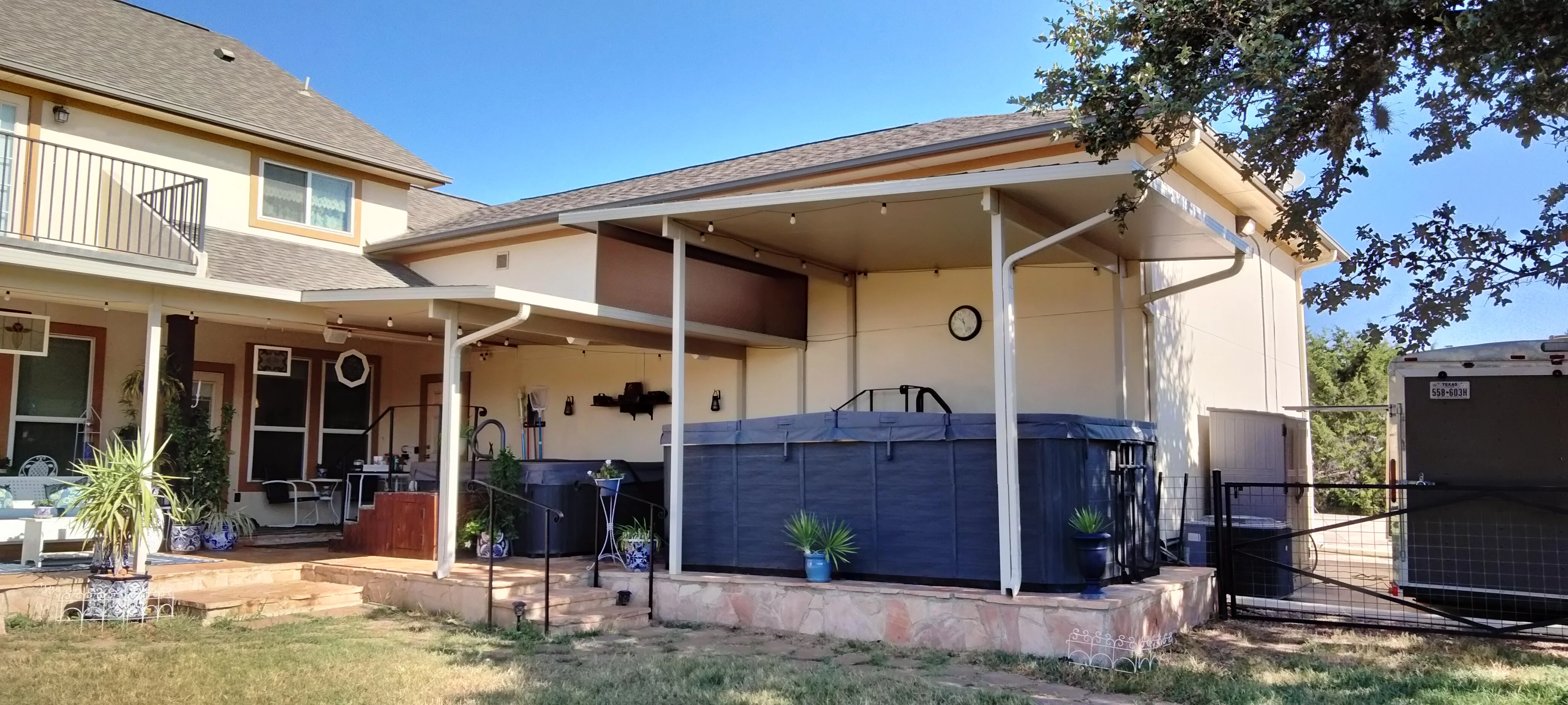 White aluminum patio cover with retractable navy screens and recessed lighting