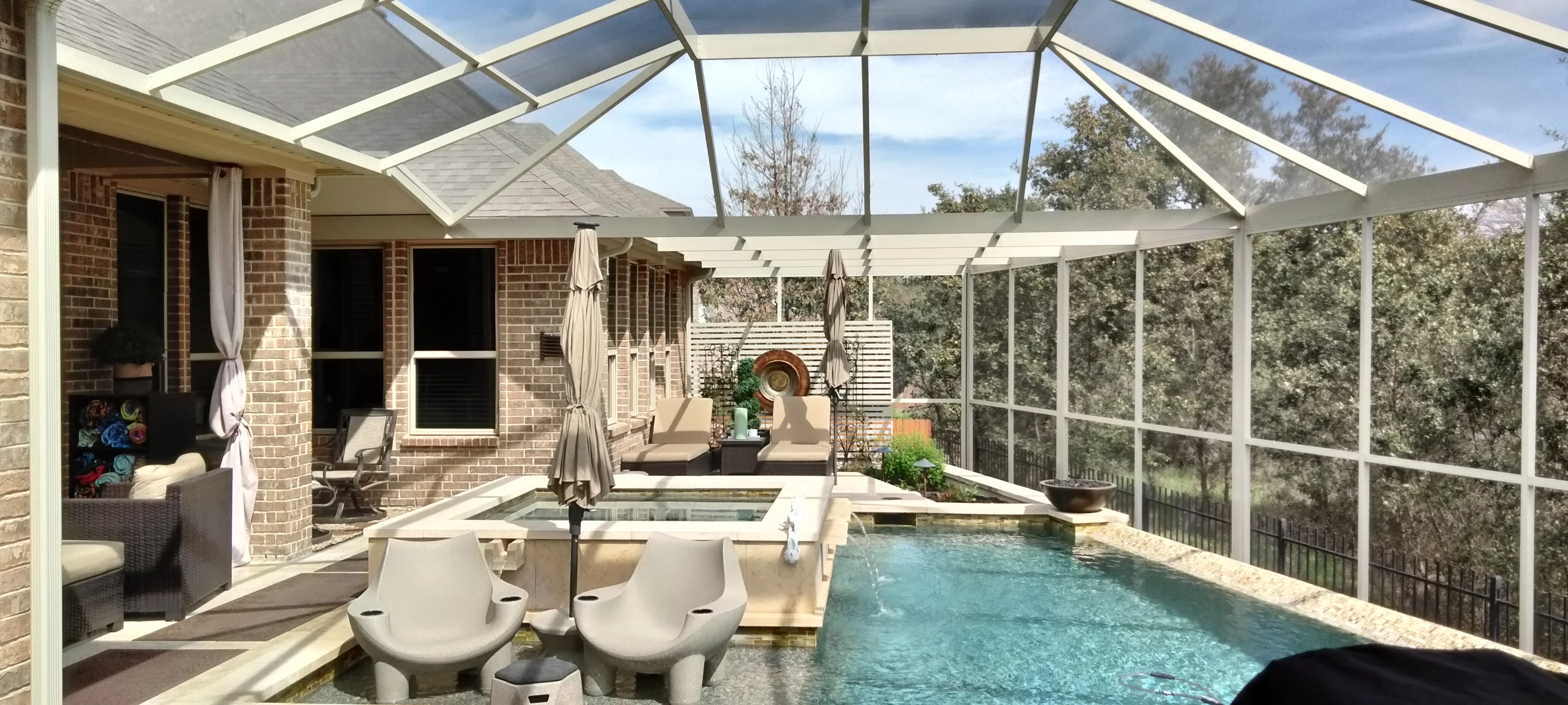 Sunroom with polycarbonate roof, aluminum frame, glass panels, and integrated spa with lounge seating