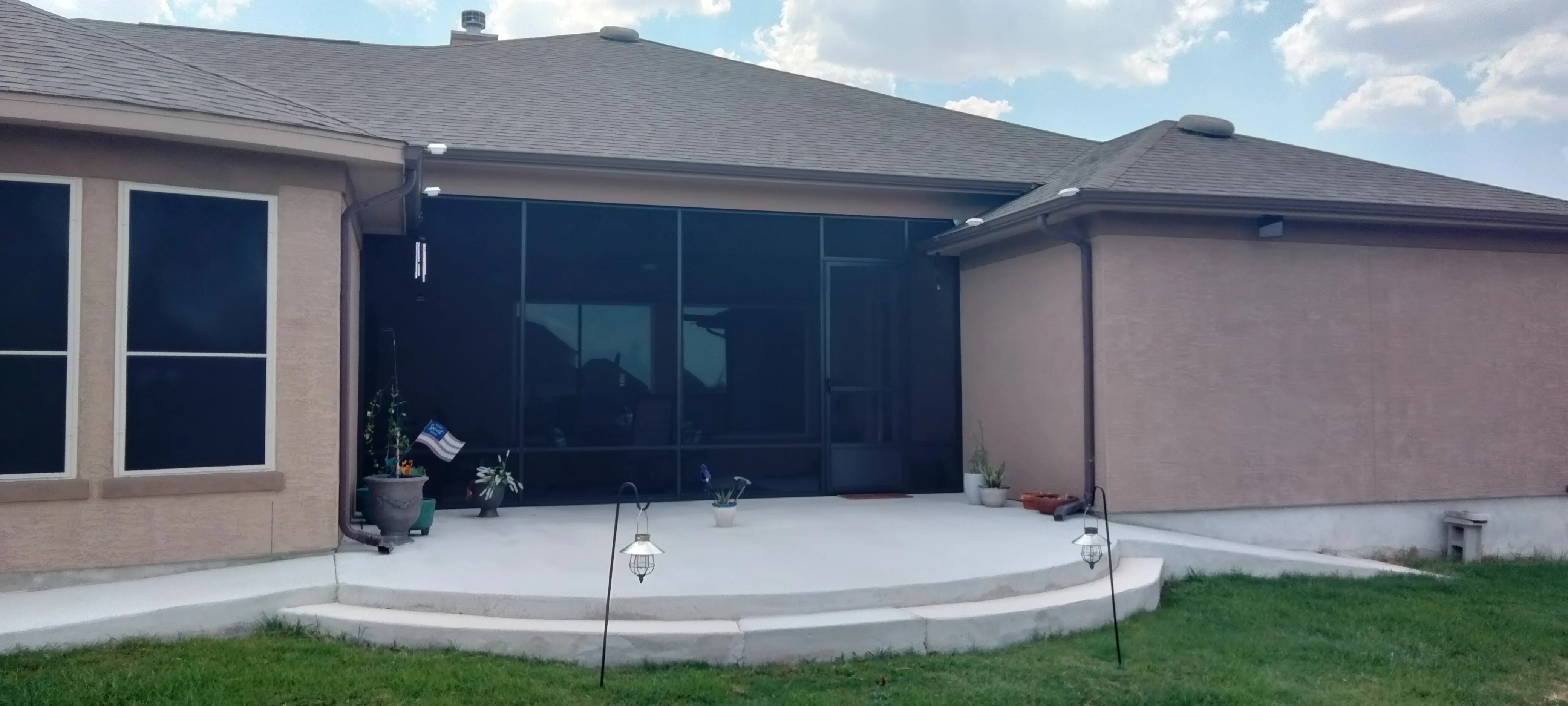 Curved concrete patio with retaining wall and step detail against brick home