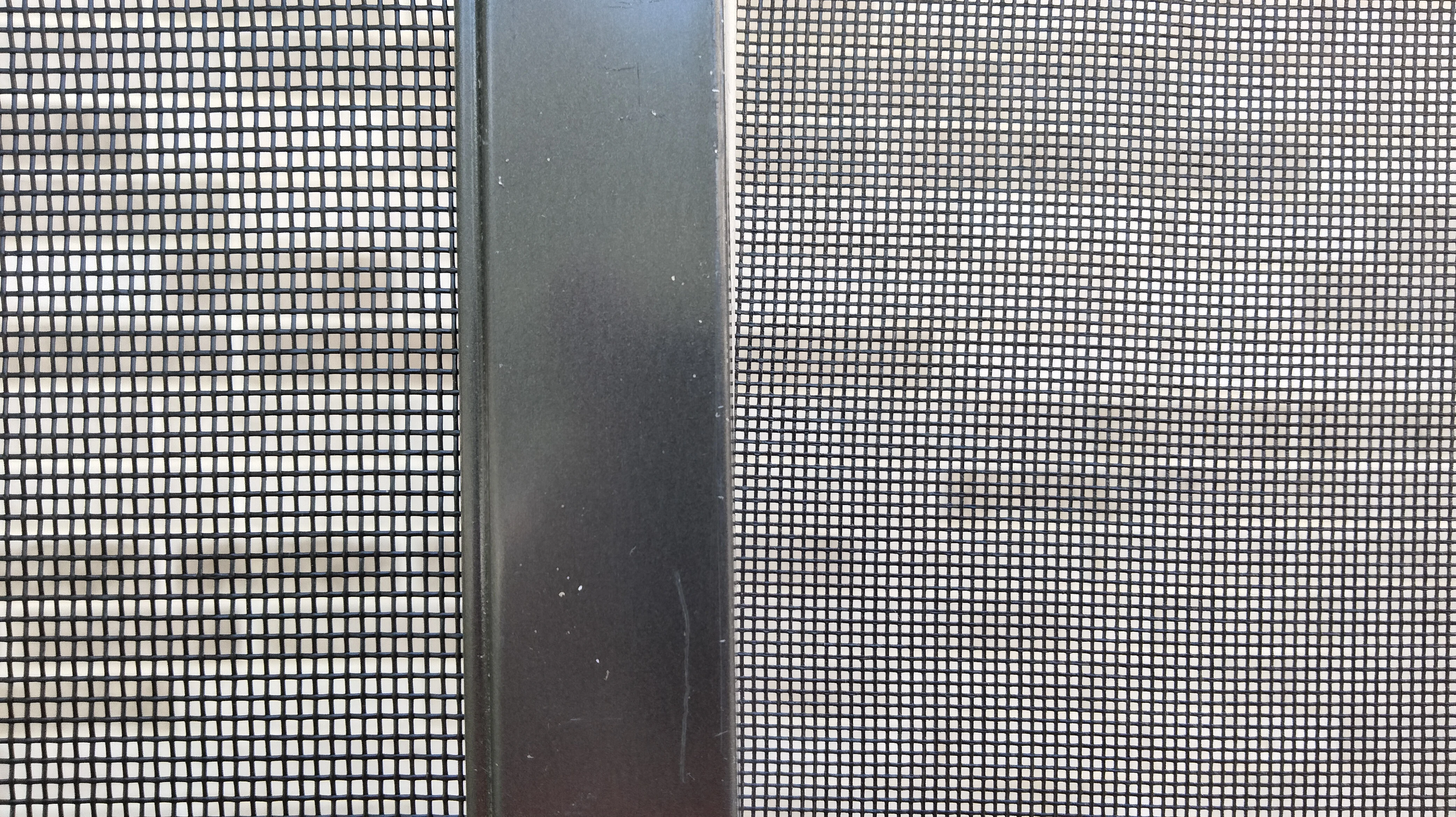 Side-by-side comparison of super screen and NoSeeum screen mesh with aluminum frame divider