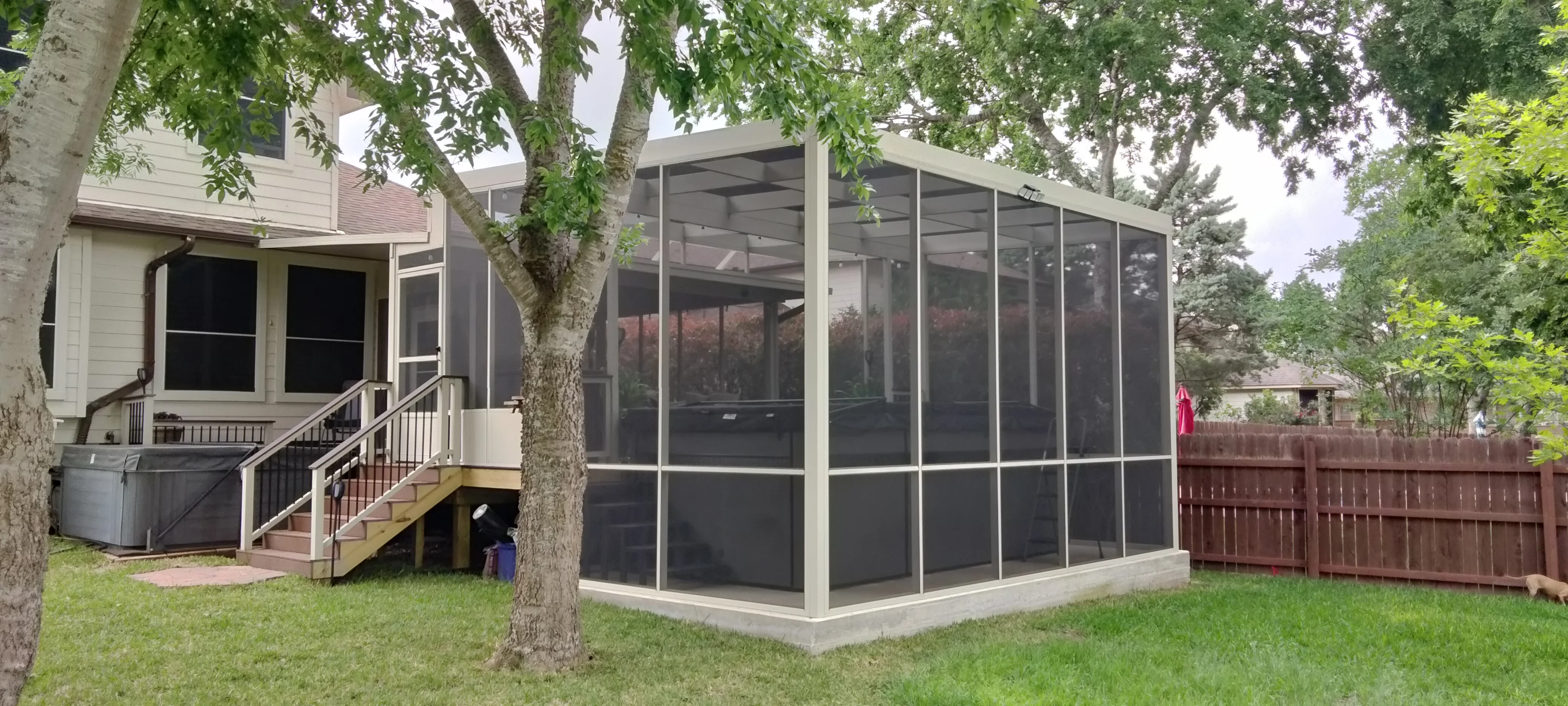 Aluminum frame pool enclosure with dark mesh screening and white posts