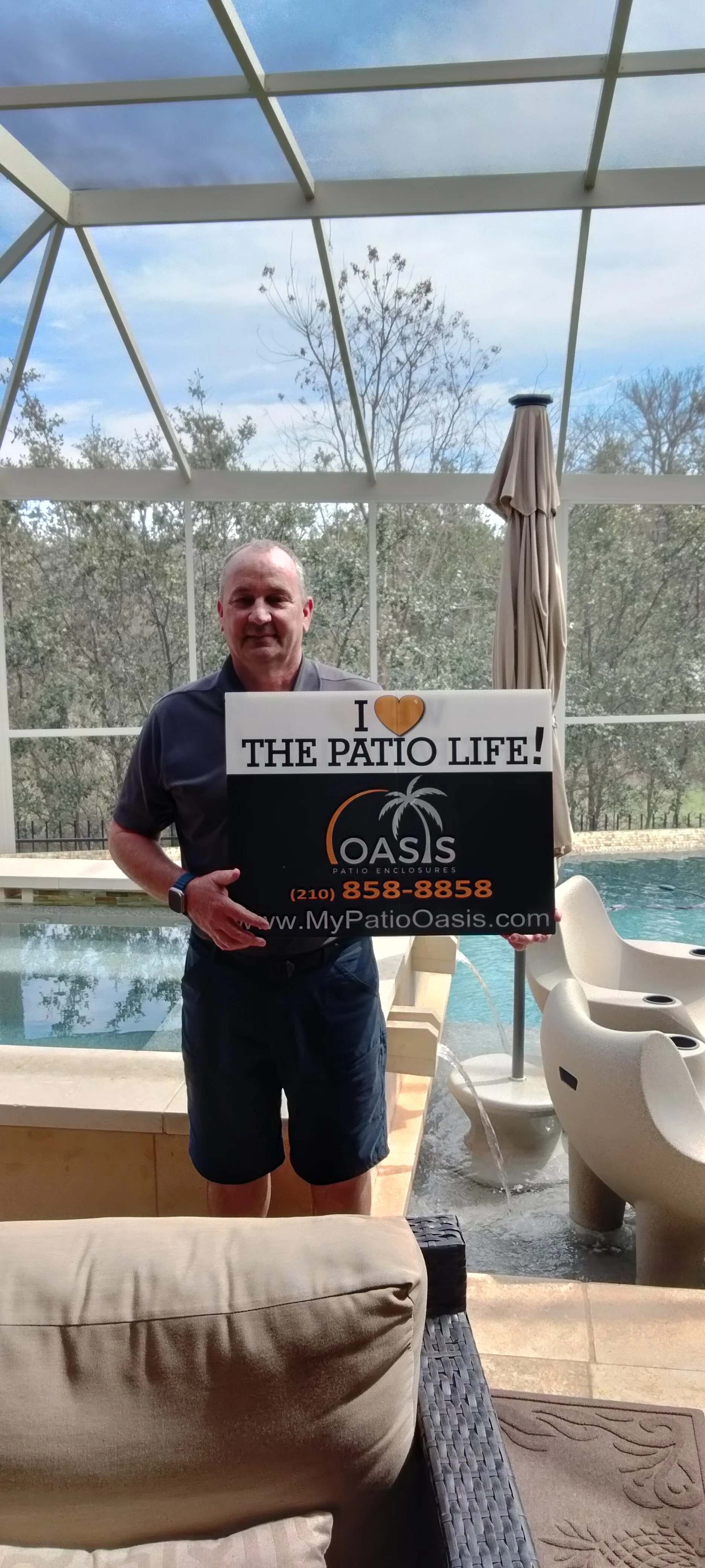 Aluminum patio enclosure with glass panels, structural beams, and pool view