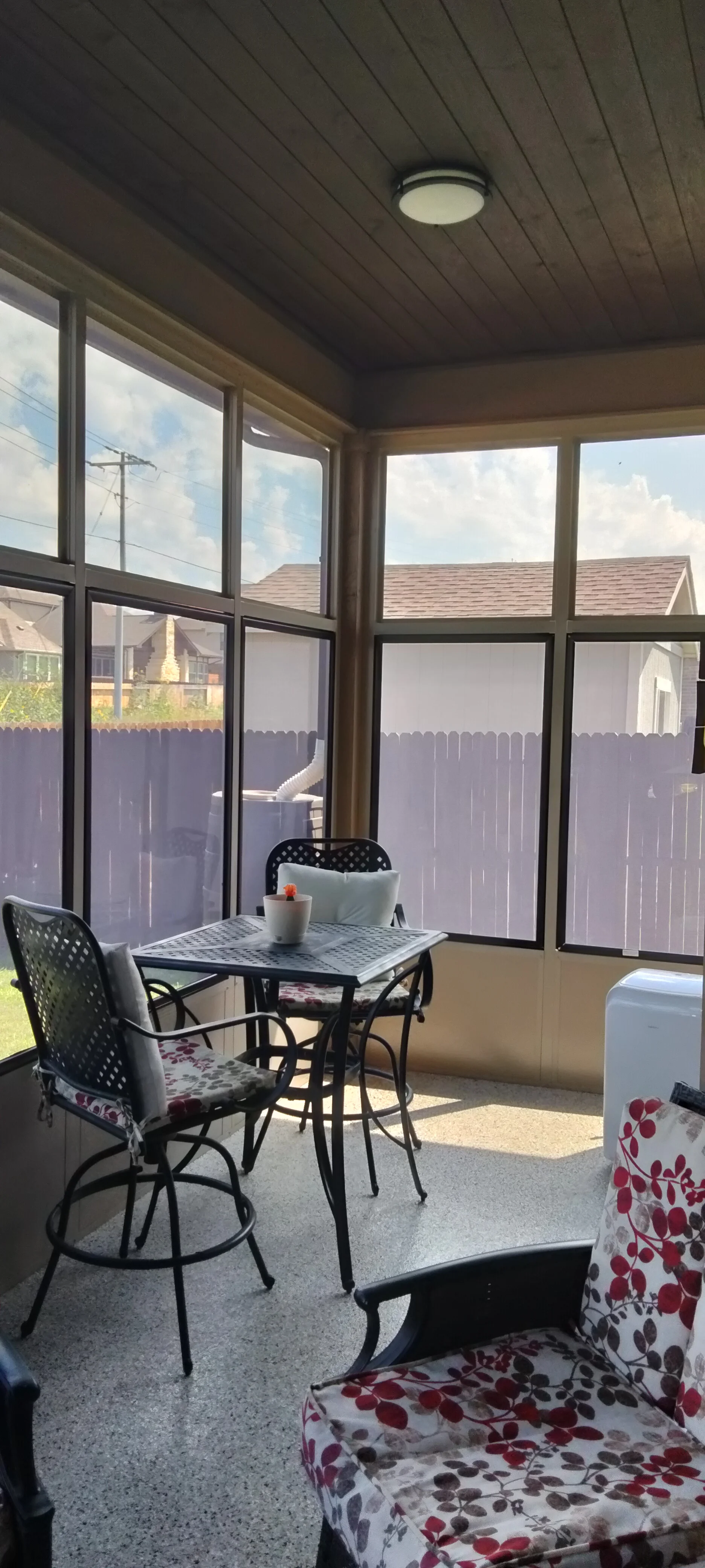 Screened patio with black vinyl windows, wood ceiling, and recessed lighting